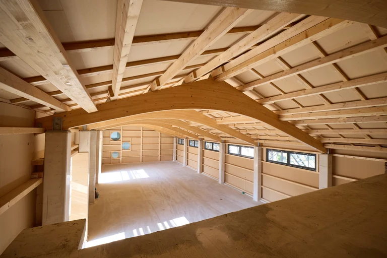 The longitudinal section of the building is being constructed using timber frames and will be insulated with wood shavings.